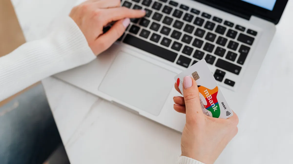 A hand holding several credit cards
