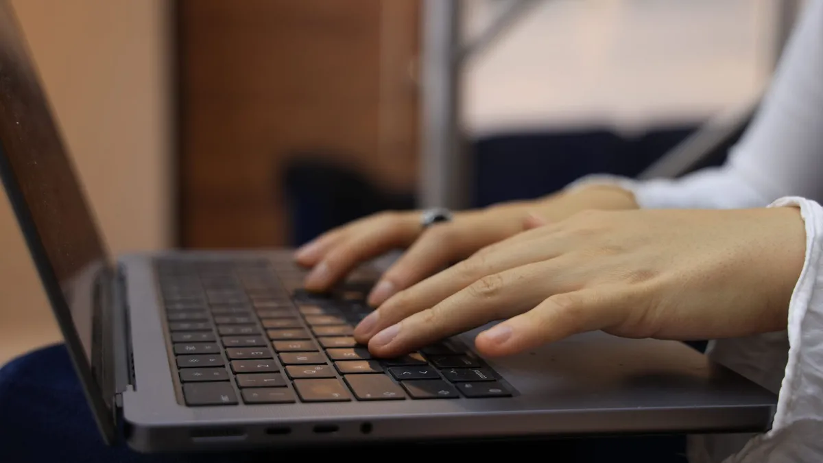 Hands typing on a laptop keyboard