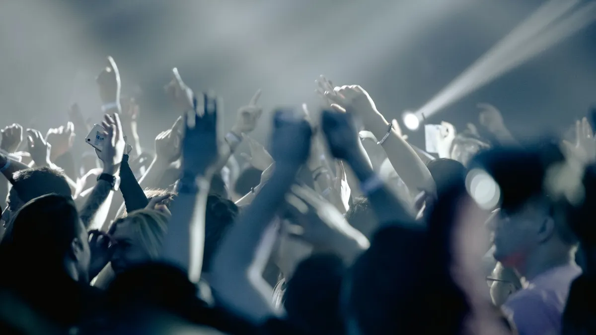 An excited crowd with hands raised