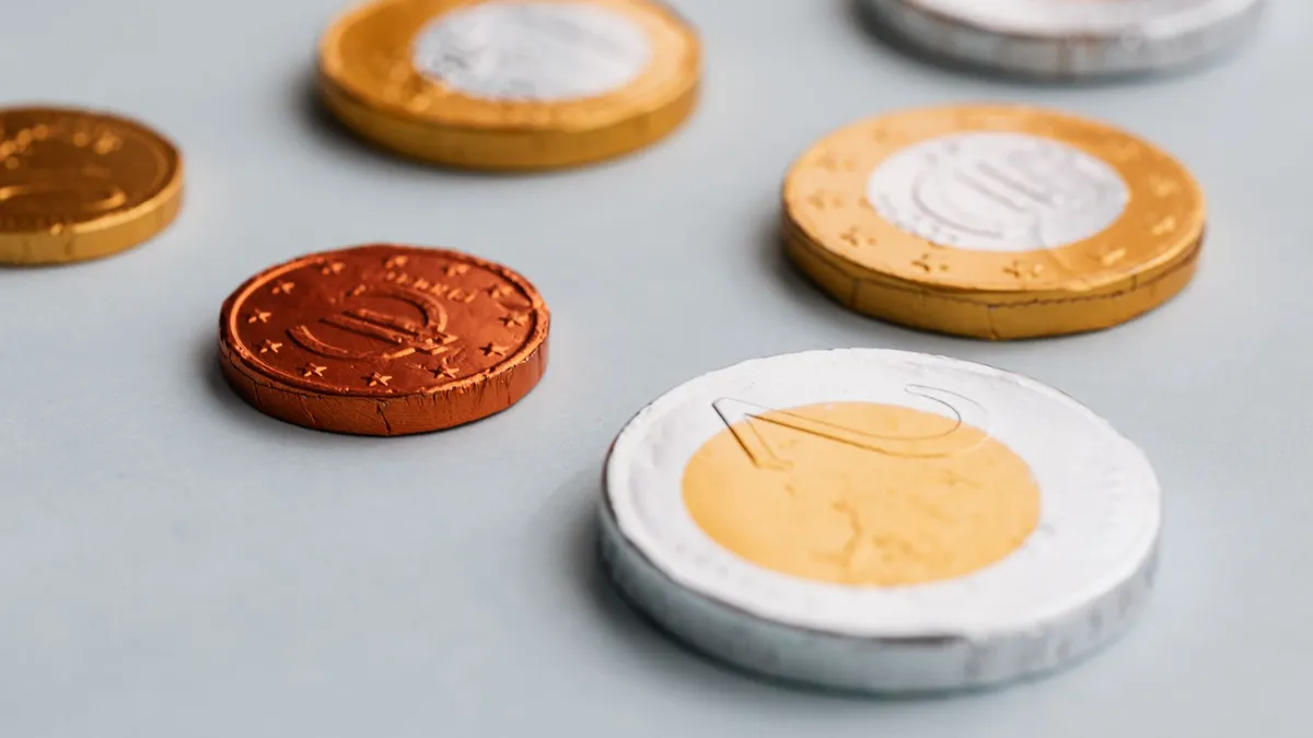 Scattered coins on a dark surface
