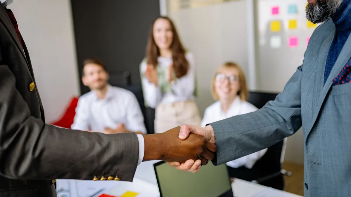 Two people shaking hands in an office